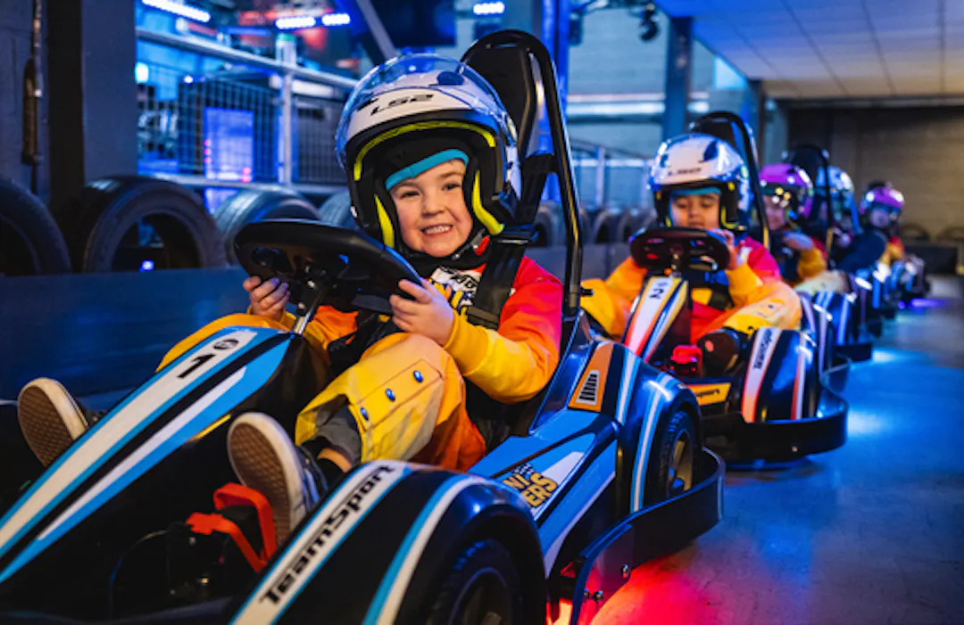 Child enjoying their first go karting experience in a mini racer