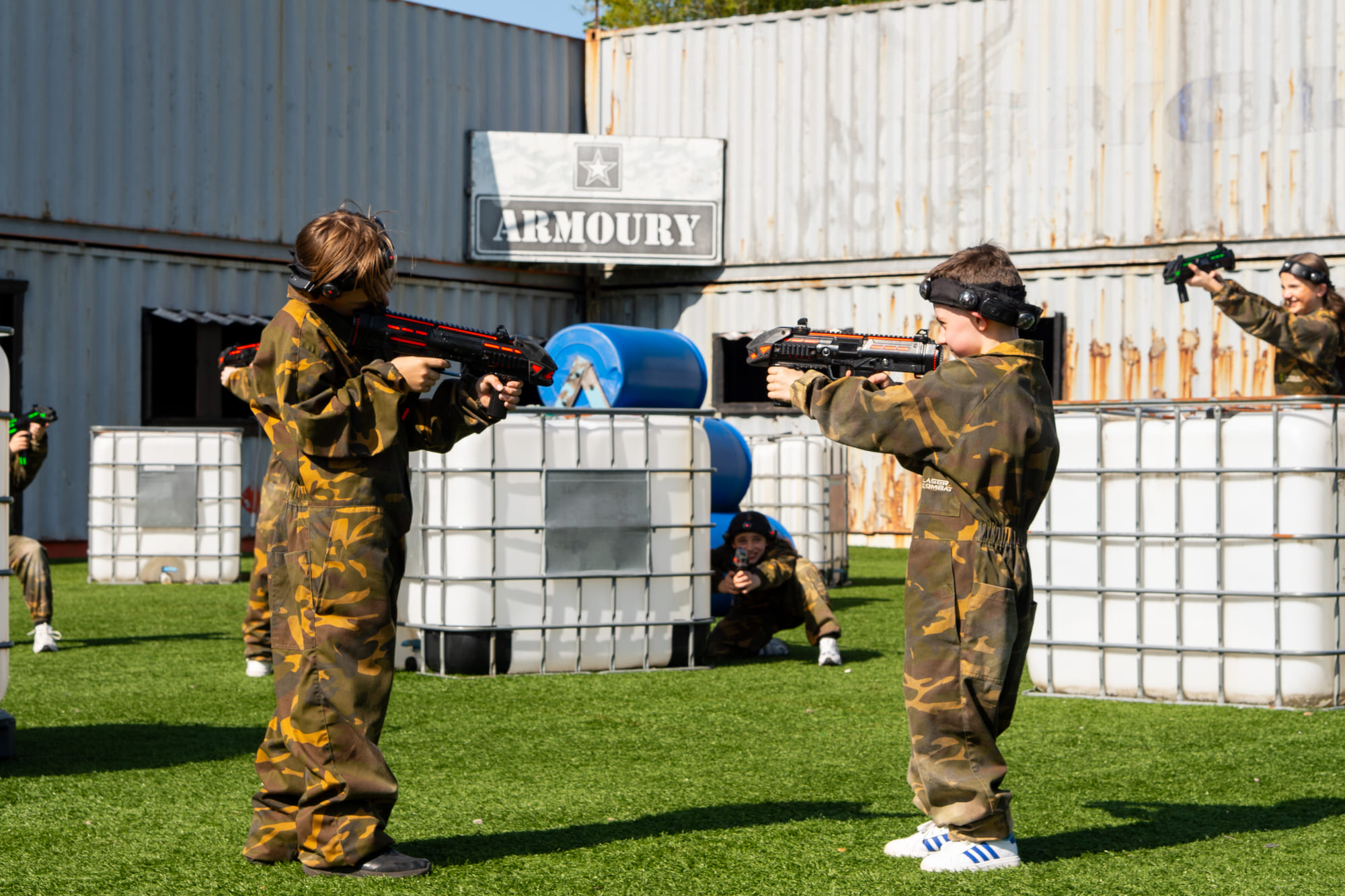 Players taking part in outdoor laser combat with cover and open battlefield space