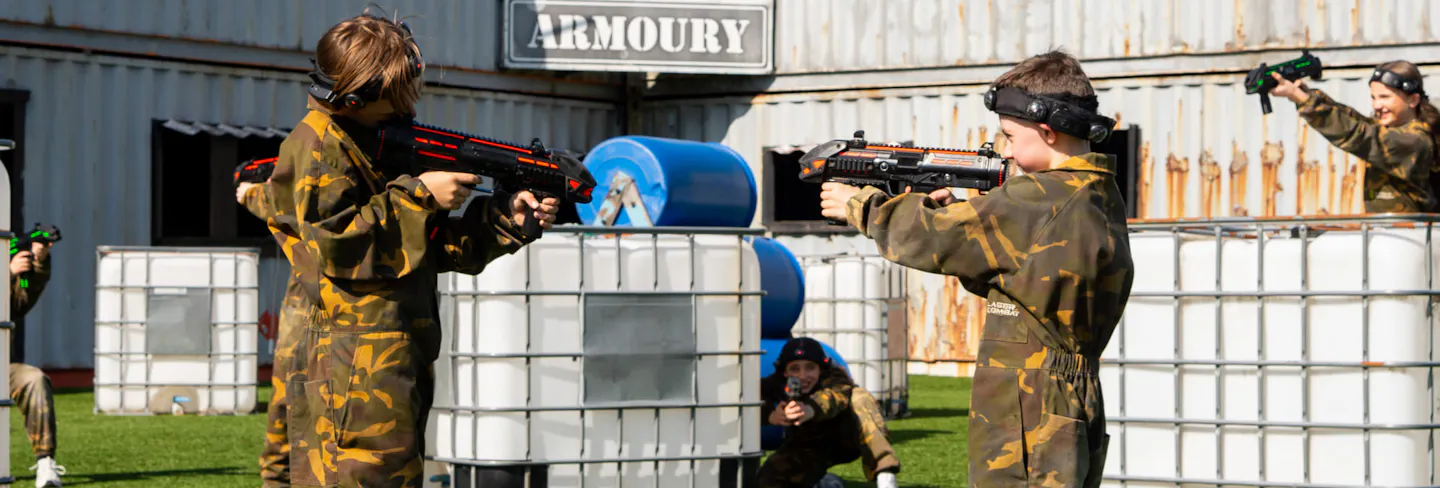 Players taking part in outdoor laser combat with cover and open battlefield space