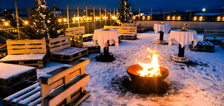 Weihnachtlich geschmückte Dachterrasse mit Schnee und Lagerfeuer