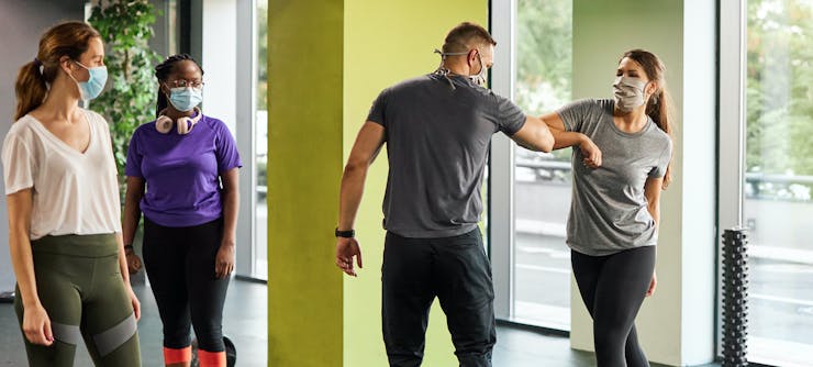 fitness instructor welcoming customers back to class