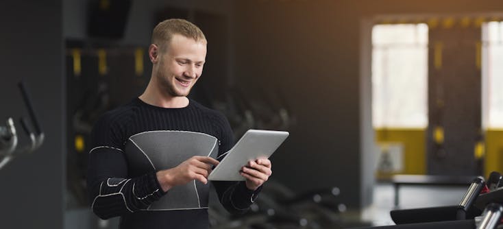 gym owner checking his reports on his tablet