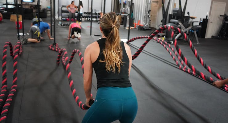 girl at the gym working out with ropes