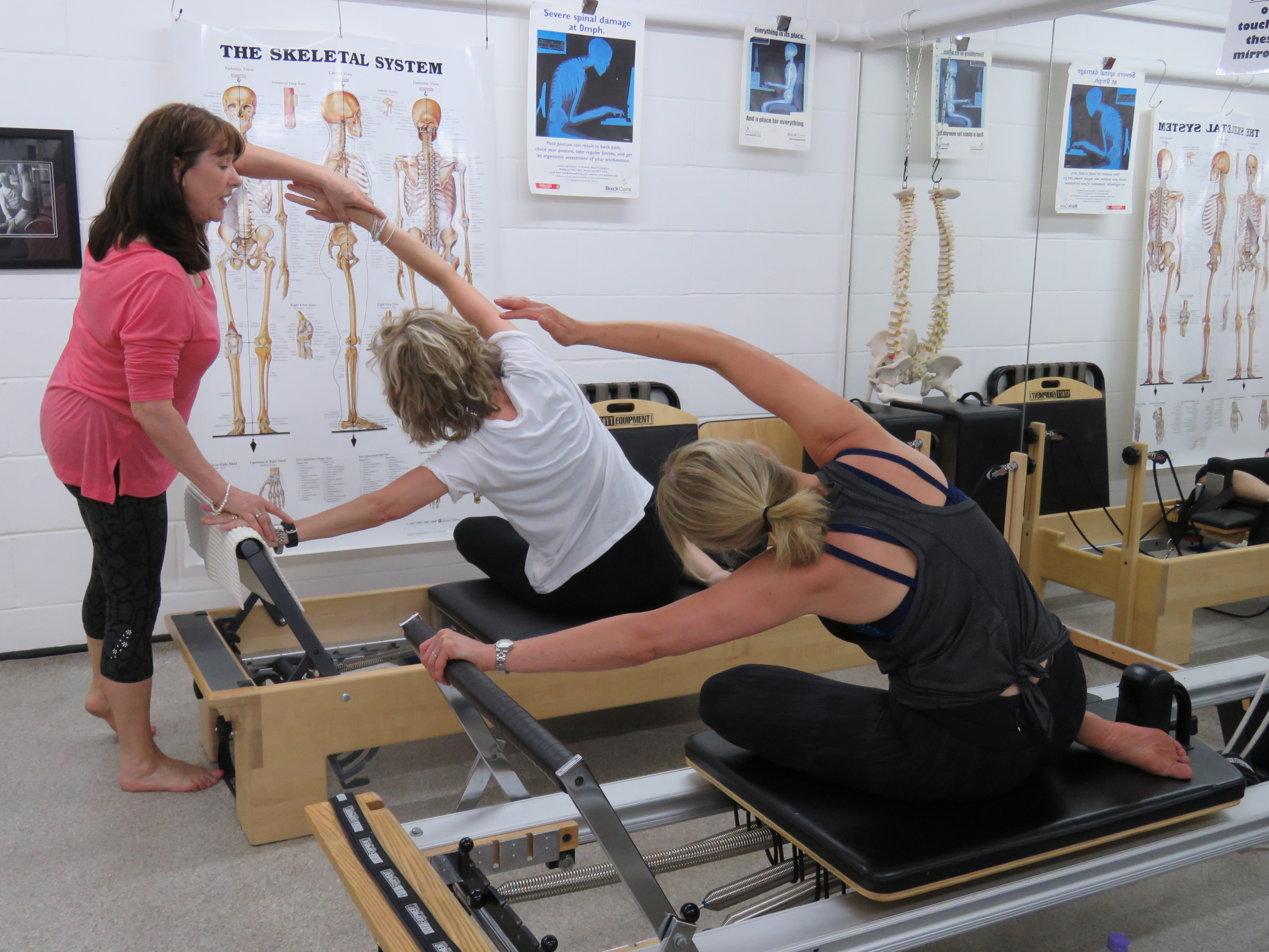 karen helping a pilates student during class