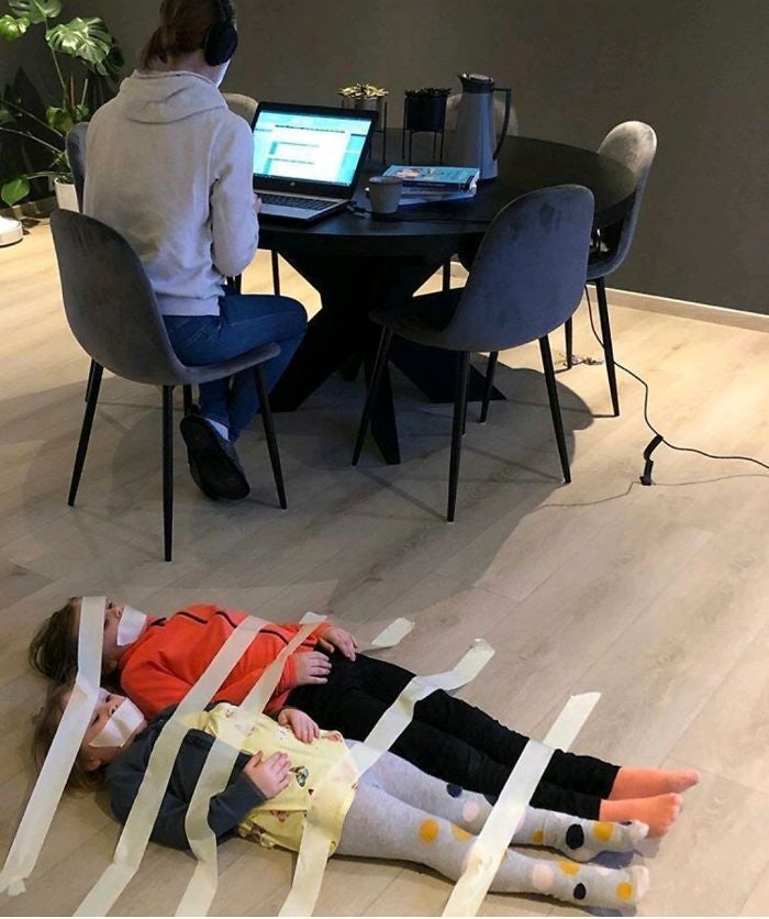A person working and two kids taped to the floor.