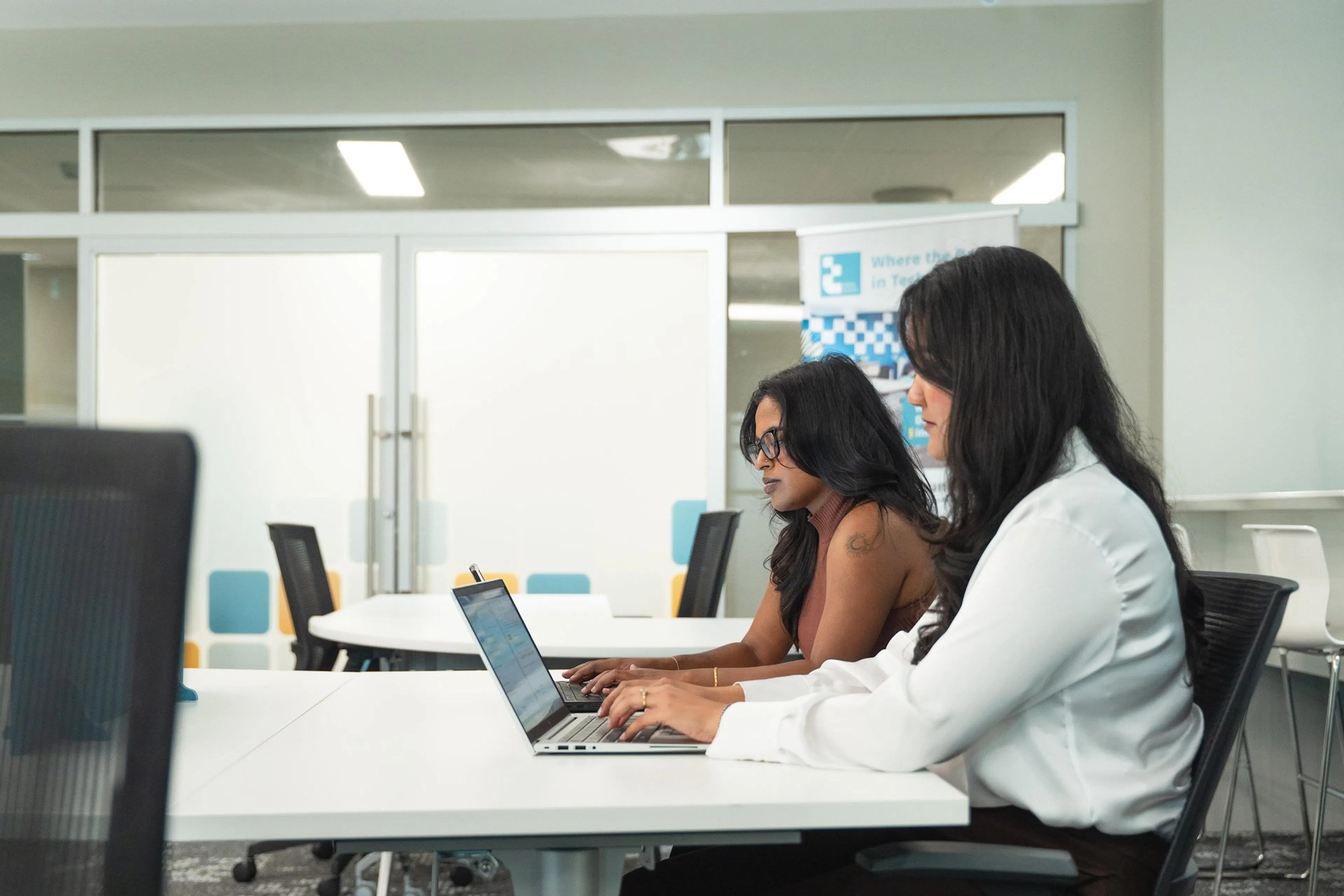 Two women working on laptops in co-working space