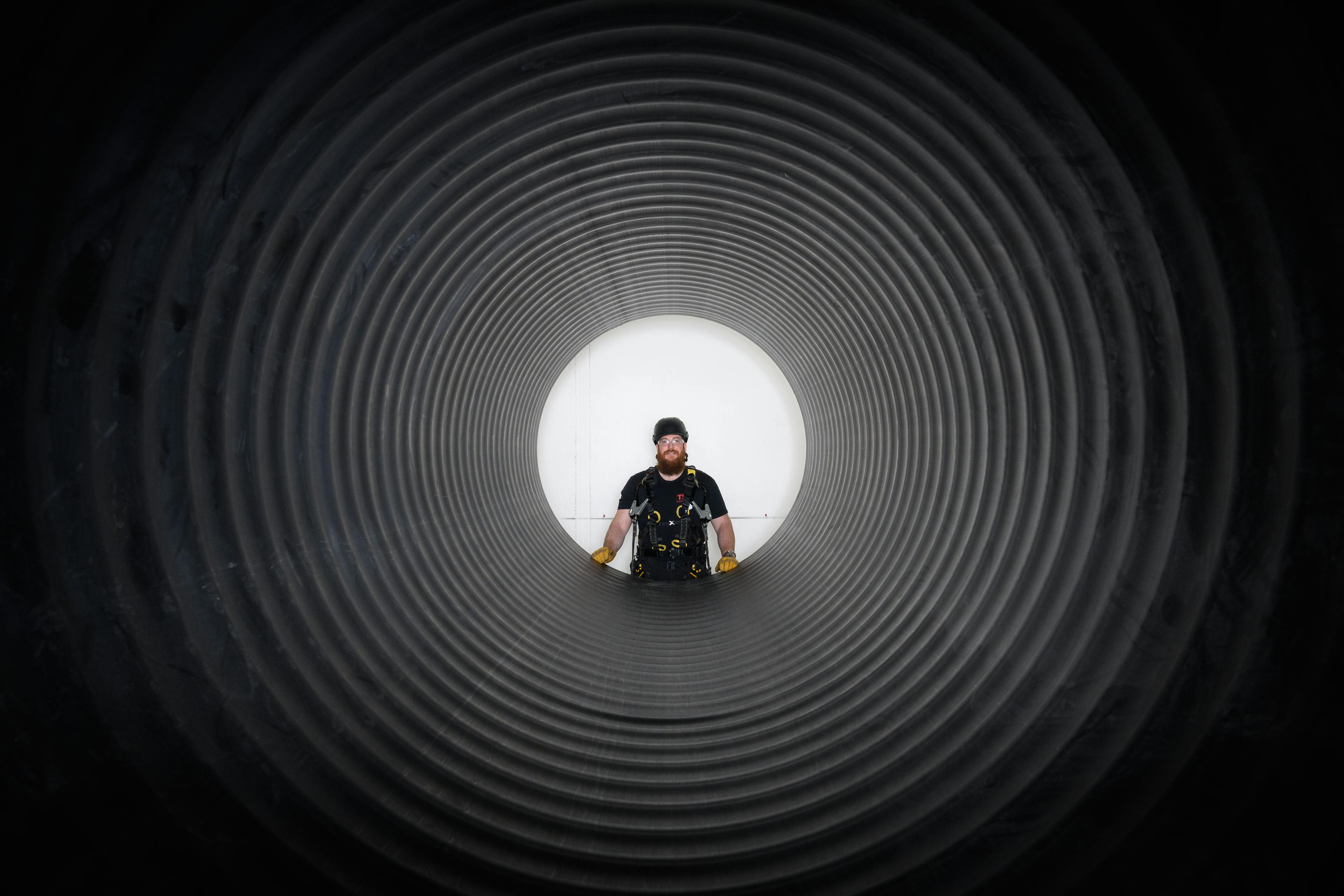 Man Standing At The Opening of a Pipe