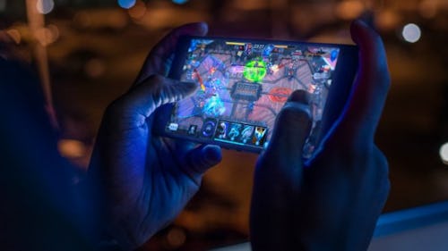An individual playing game on a smartphone.