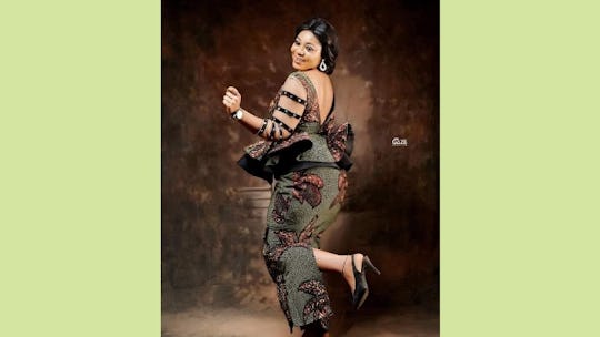 A woman wearing a peplum V back ankara dress