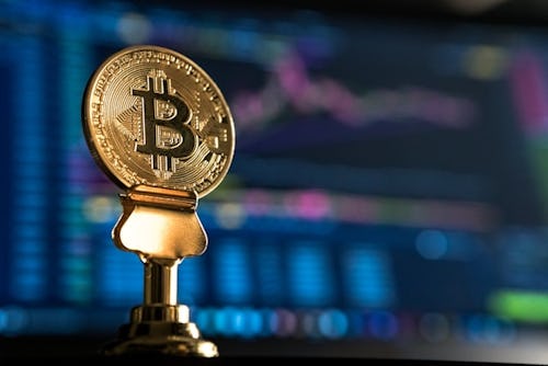 selective focus photo of Bitcoin near monitor