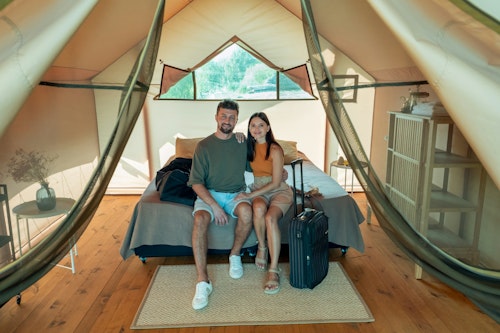 A couple on a honeymoon inside a chalet with their luggage