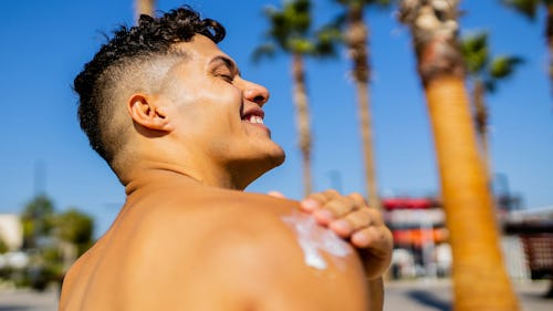 Image of a man applying SPF sunscreen during the day to prevent sunburn