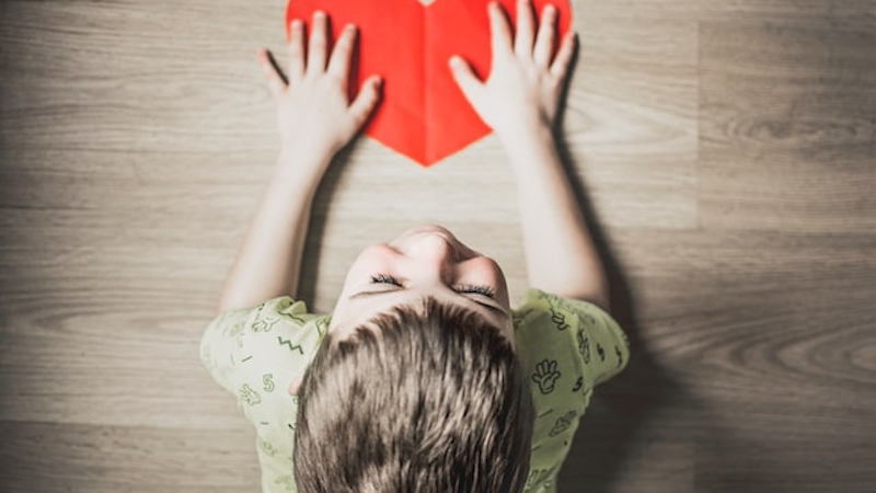 A child holding a heart-shaped paper