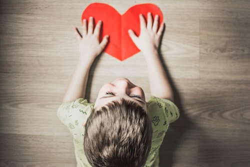 A child holding a heart-shaped paper