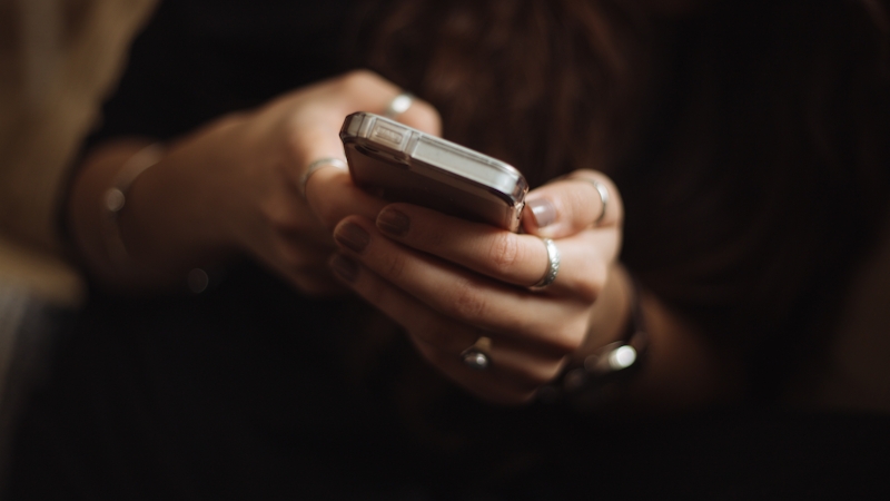 An individual accessing the internet using a mobile device.