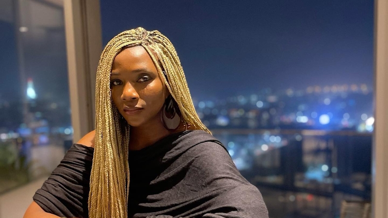 genevieve nnaji poses in a high rise building overlooking an urban city