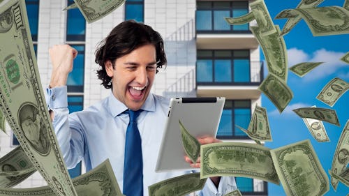 Image of a man wearing a suit and a tear holding an ipad with dollar notes flying around him