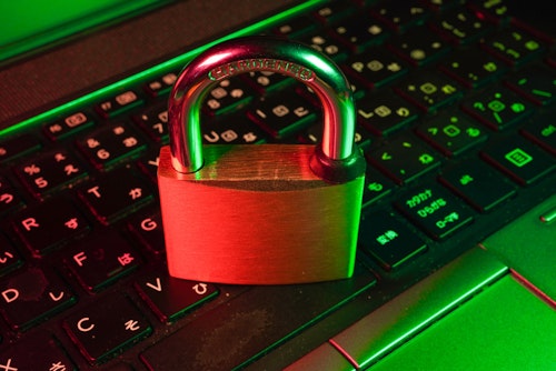 A pad lock sits atop the keyboard of a laptop