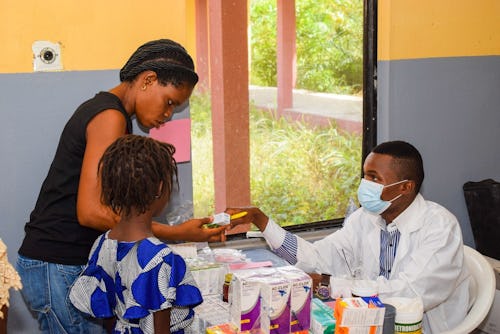 Black pharmacist dispensing medication to a black patient
