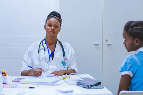 A doctor treating a girl with malaria