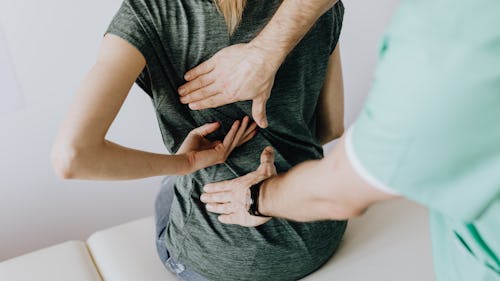A massage therapist massaging a patient with back pain