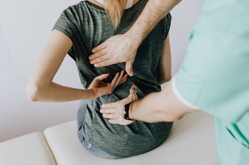 A massage therapist massaging a patient with back pain