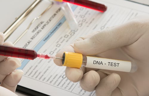 A lab technician taking blood sample for DNA test with a syringe