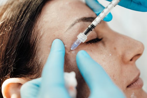 A woman getting an injection on the face for facial skincare