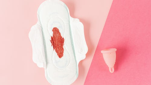Image showing a menstrual cup and a menstruation pad with blood stain