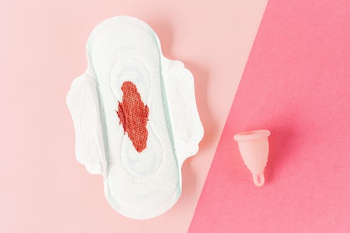 Image showing a menstrual cup and a menstruation pad with blood stain