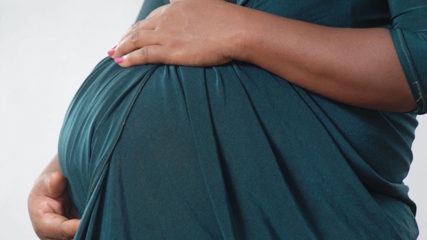 Black pregnant woman holding her tummy