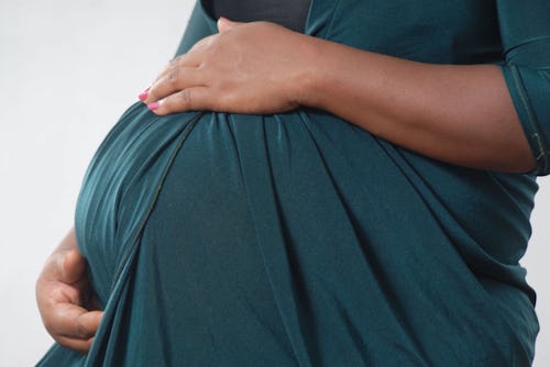 Black pregnant woman holding her tummy