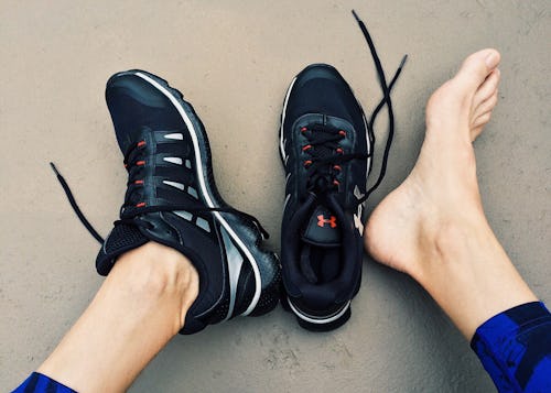 A person with bunions wearing sneakers on right leg and bare foot on left leg