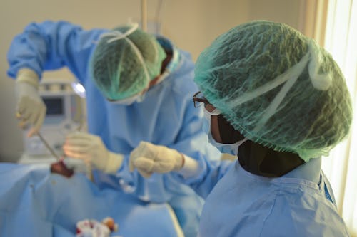 A black doctor and a black nurse in a surgery room operating on a patient