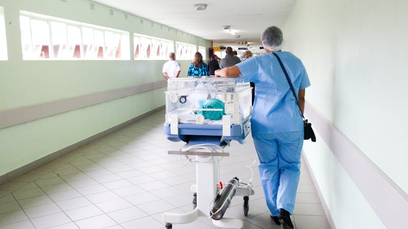 A nurse carrying an incubator in a Nigerian hospital