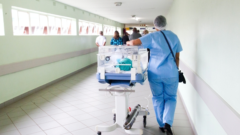 A nurse carrying an incubator in a Nigerian hospital