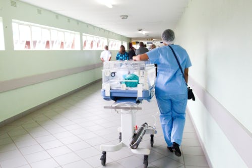 A nurse carrying an incubator in a Nigerian hospital