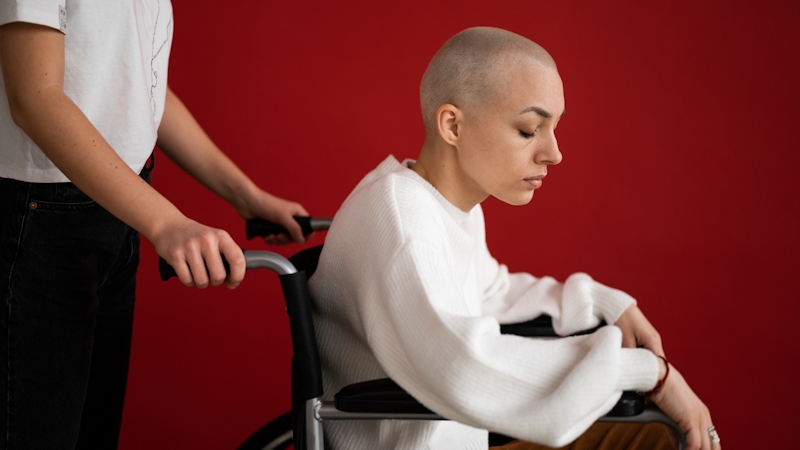 A woman with cancer carried into the hospital for chemotherapy