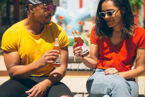 A man and a woman drinking energy drinks