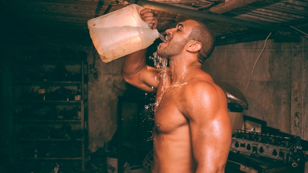 A well-built man with six-packs abs drinking water