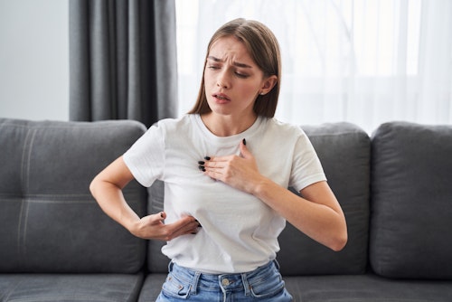 A lady experiencing breast pain (tenderness) due to menstrual cycle hormonal fluctuations