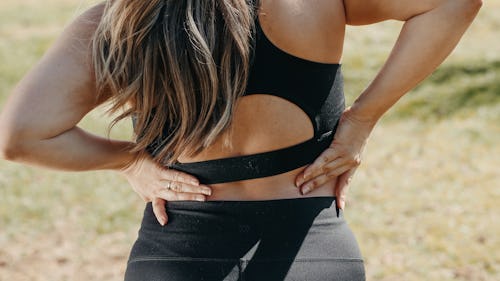 A lady rubbing her hands on her lower back