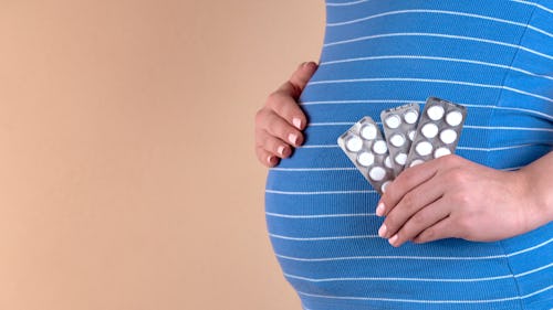 A pregnant woman taking holding three drug pills