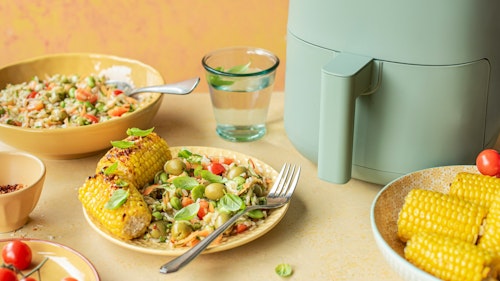 Image showing varieties of food on a table including corn, vegetables, tomatoes and a glass of water