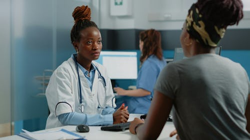 Female patient speaking with with a female doctor with a stethoscope on her neck