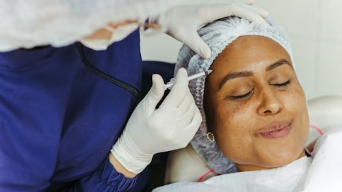 A woman getting a botox (botulinum) injection on her forehead