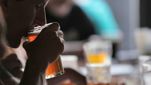 Image of a man drinking alcohol (beer) at a bar