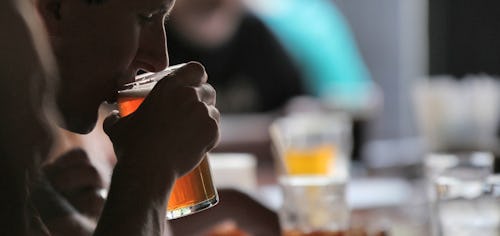 Image of a man drinking alcohol (beer) at a bar