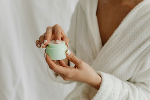 image of a woman applying a skincare moisturizing product