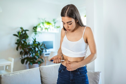 Image of a girl injecting insulin hormone into her abdomen